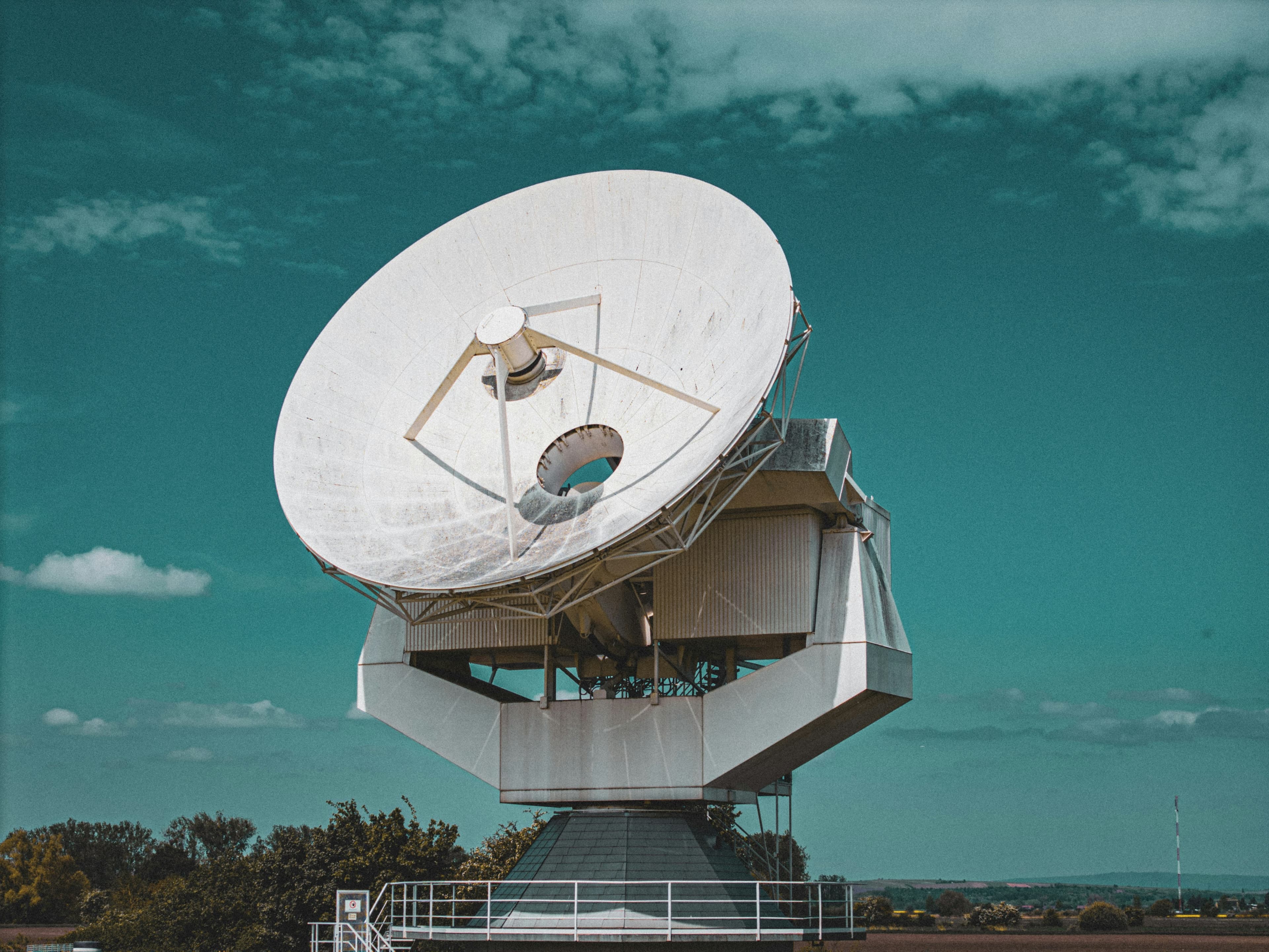 A large satellite dish installed on a building's roof, capturing signals from space.