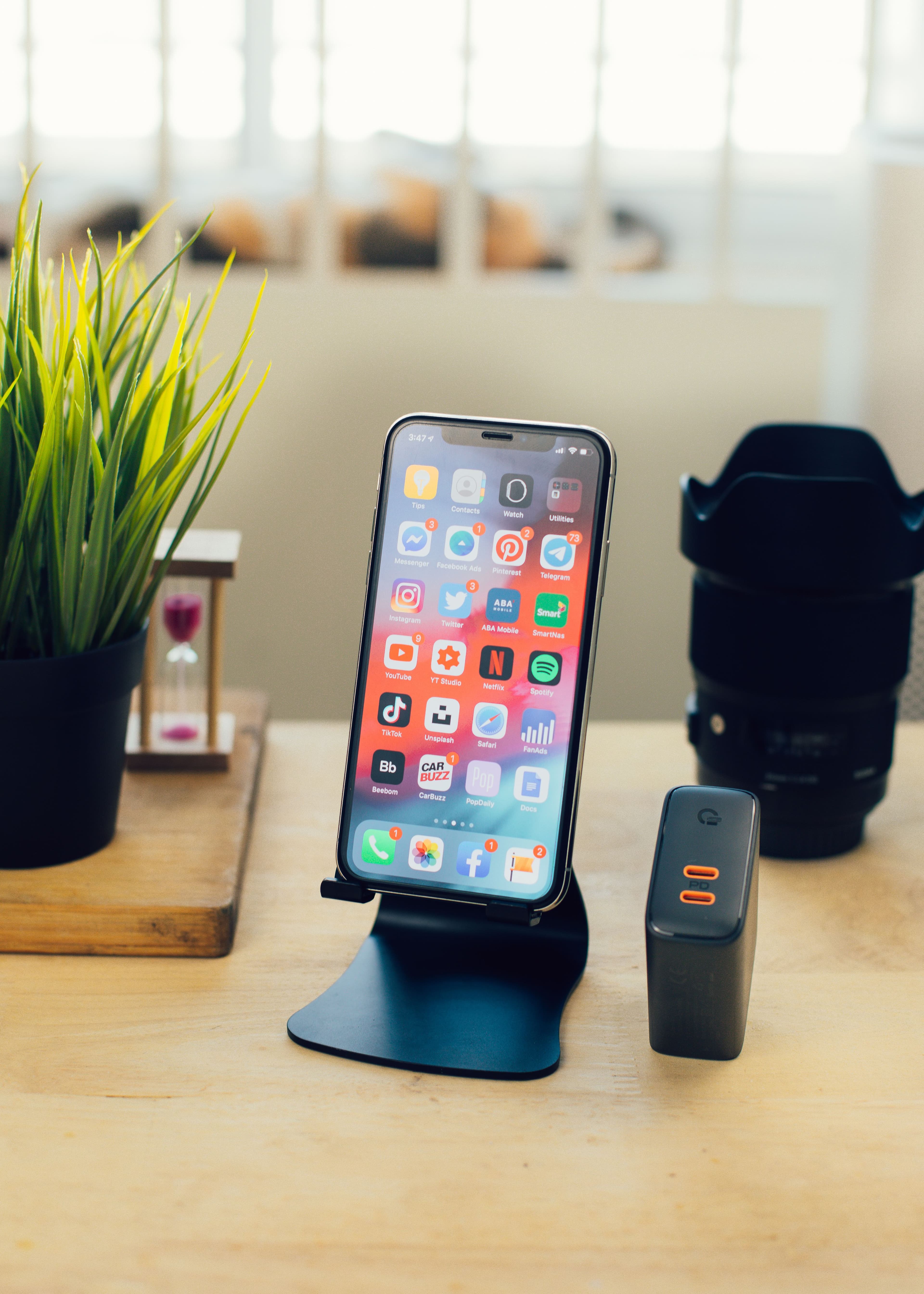 A smartphone resting on a wooden table, displaying a colorful home screen.