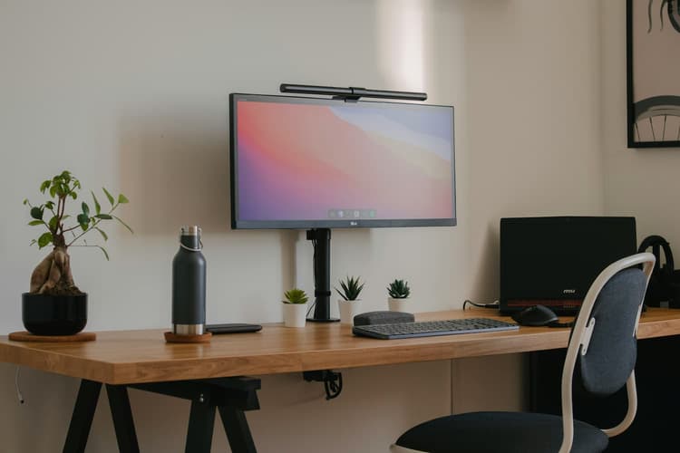 A desk featuring a computer monitor and an office chair, creating a workspace setup.